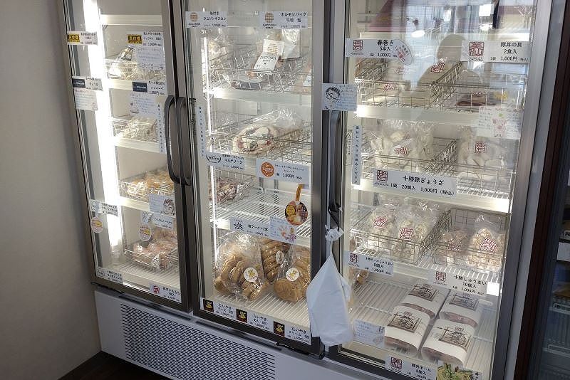 冷凍ショーケースに並ぶ地元の美味しい人気商品の餃子やピザなど