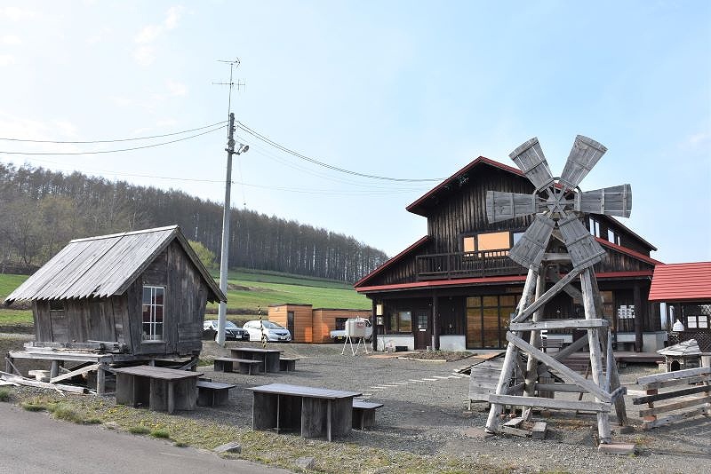 山小屋風の宝水ワイナリーと、その前にたたずむ、映画のロケで使われた木製風車