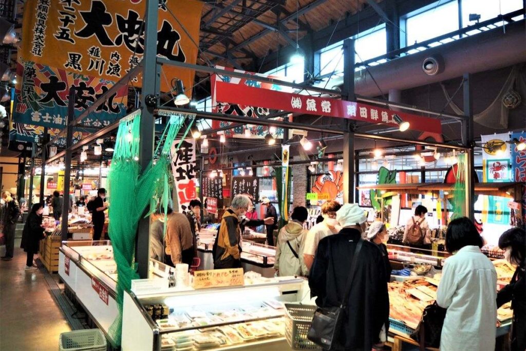 大漁旗なども飾られ、にぎやかな雰囲気の明田鮮魚店の店内