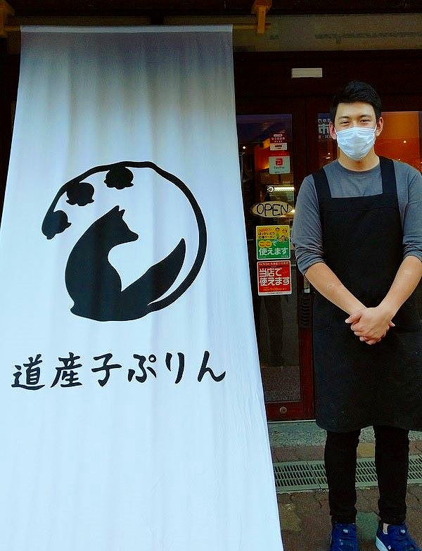 登別初のぷりん専門店「道産子ぷりん」の外観と店の前に立つ美濃井さん
