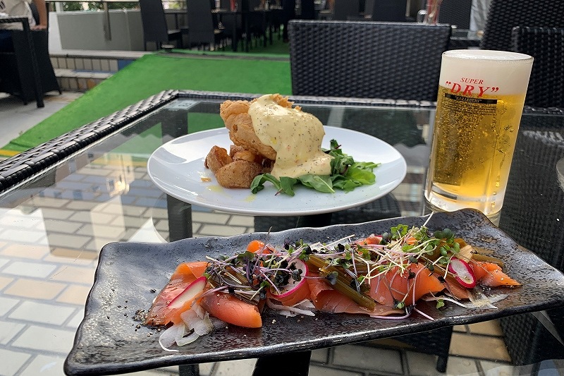 さっぽろ東急ビアガーデン2階テラス プレミアムリゾートが提供しているスモークサーモンと葉わさびのカルパッチョ風（手前）とフィッシュアンドチップス