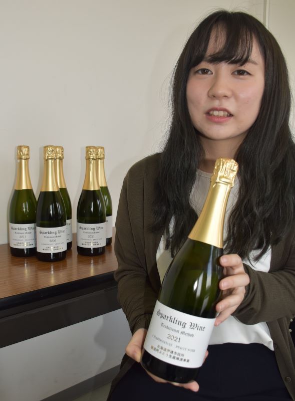 伊達産ブドウで初めて醸造されたスパークリングワインを手にする関係者