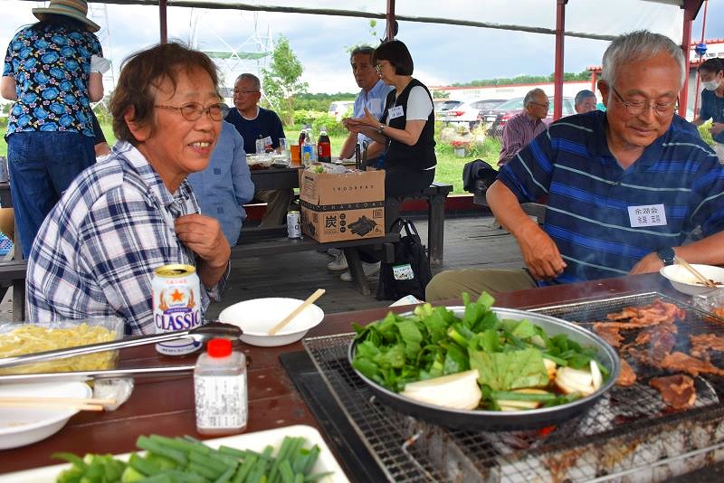 網で直接焼いた肉や、鍋で蒸し焼きにした野菜を味わう客