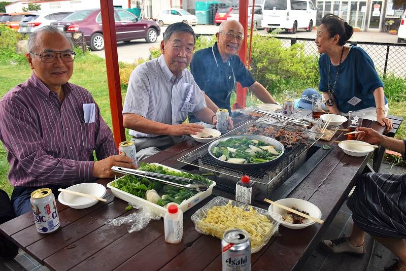 コンロを前に焼いた野菜を味わうグループ客