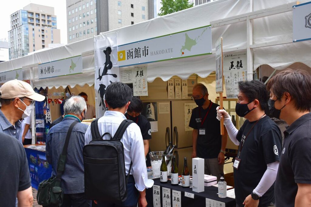 ブース前で五稜乃蔵の試飲をする来場者
