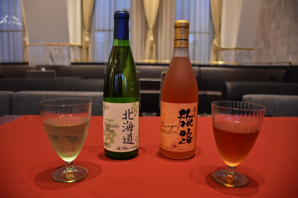 提供されている北海道ワイン2種類のボトルとワインが注がれたグラス