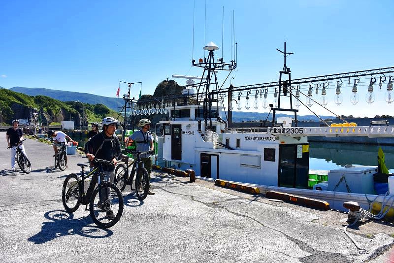 ツアーの途中に立ち寄った漁港を散策する参加者