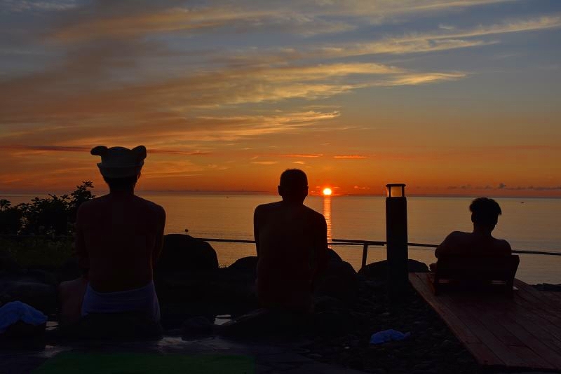 日本海に沈む夕陽を楽しむ参加者