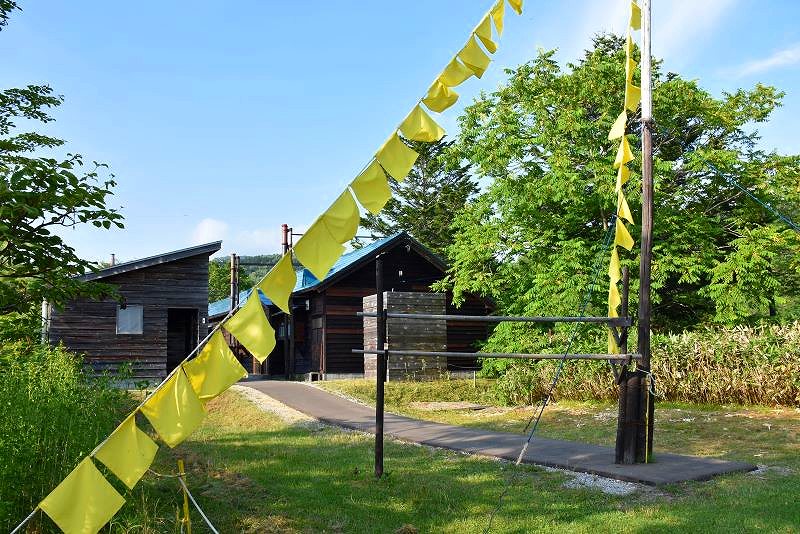 炭鉱住宅長屋の奥で風にゆれる無数の黄色いハンカチ