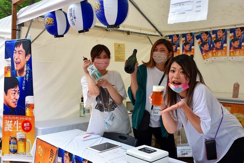 アルコールを販売提供しているブースで笑顔を見せる女性スタッフ