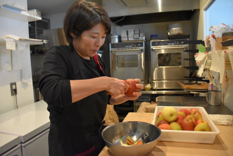 リンゴの皮をむく金田さん