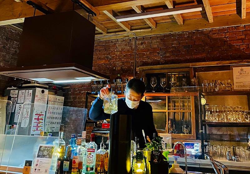 カウンターでお酒をつくるタクシードライバーのバーテンダー