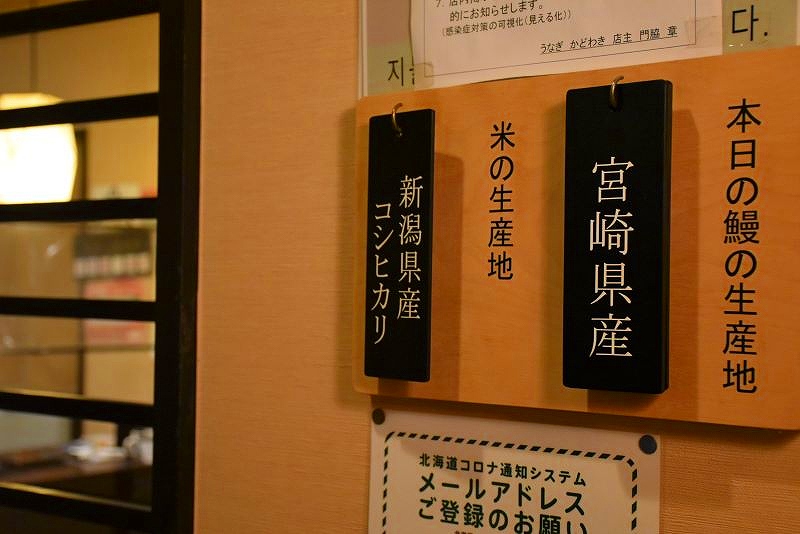 「うなぎ かどわき」の壁にかけられた、その日のウナギとお米の産地を案内する札