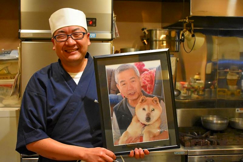 「うなぎ かどわき」先代で父の故・門脇政雄さんの写真を手にする2代目の門脇章さん