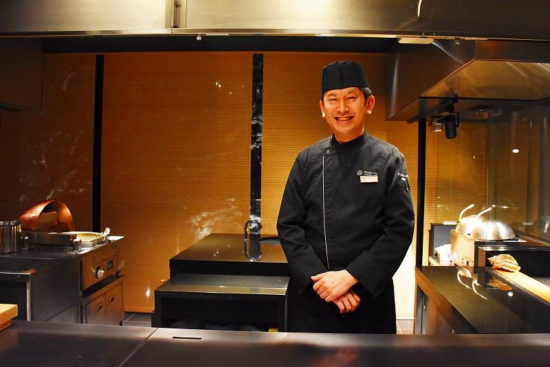 厨房に立ち笑顔を見せるレストラン「桵(ずい)」の伊藤卓也総料理長