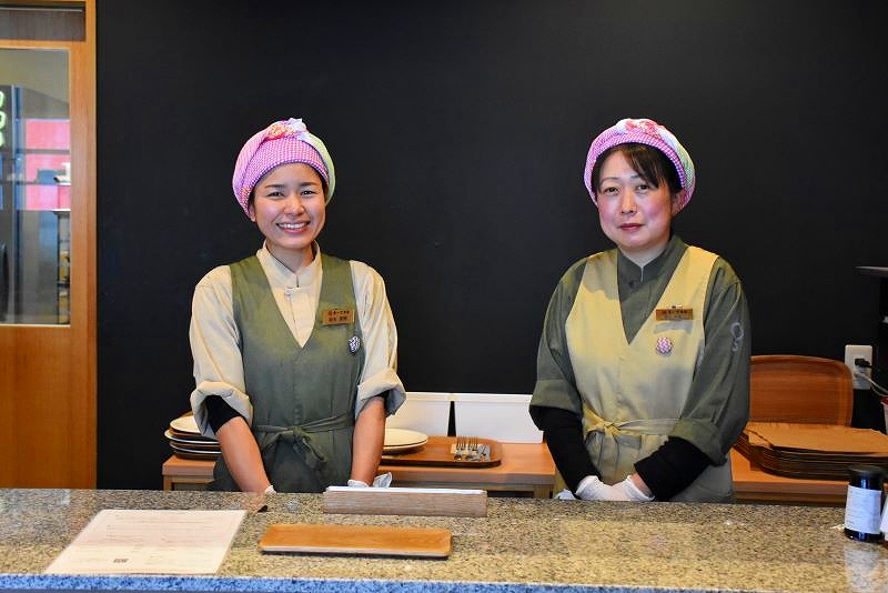 エクスクラメーションベーカリーのカウンターで笑顔を見せる2人の女性スタッフ