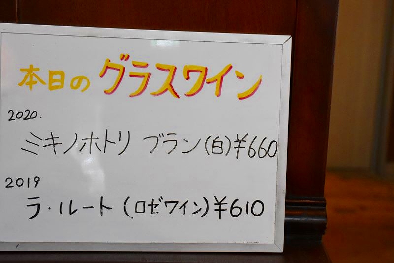 カフェ&レストラン「ヴィーニュ」の「本日のグラスワイン」の紹介と価格をお知らせするホワイトボード