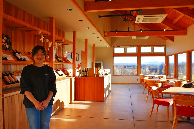 ワイナリーの店舗内で笑顔を見せながらたたずむ醸造責任者の森裕子さん