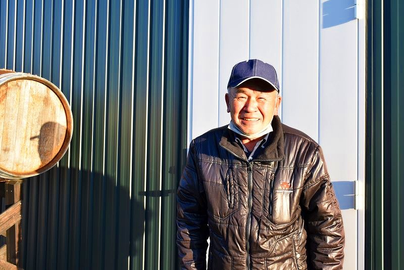 笑顔を見せるボス.アグリ.ワイナリーの深田英明さん