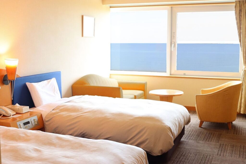 窓の外に海が広がるホテルの洋室