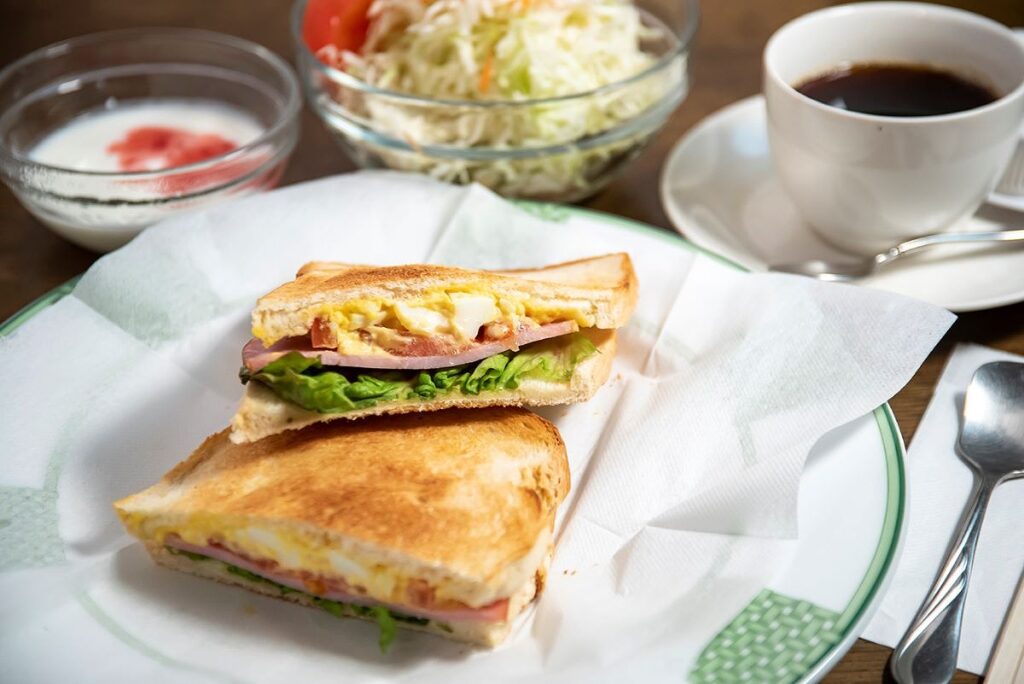 程よい厚みのトーストに、塩気の利いた玉子サラダ、ハム、トマト、キュウリ、レタスがサンドされた「珈琲店 エーデルワイス」のサンドイッチ
