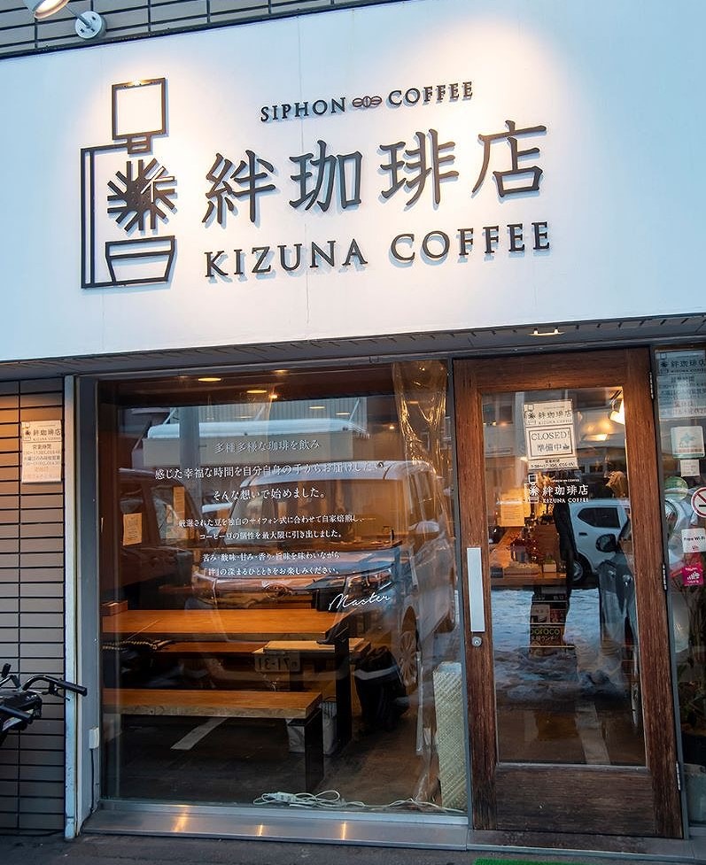 大きな白い看板が目印の「絆珈琲店（きずなコーヒー店）」の店舗外観