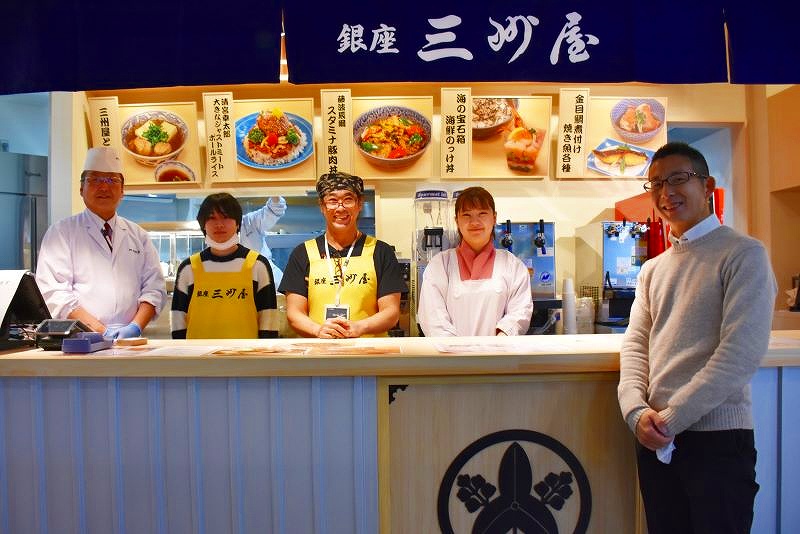 大衆割烹「銀座　三州屋」の店先で笑顔をみせる５人のスタッフたち
