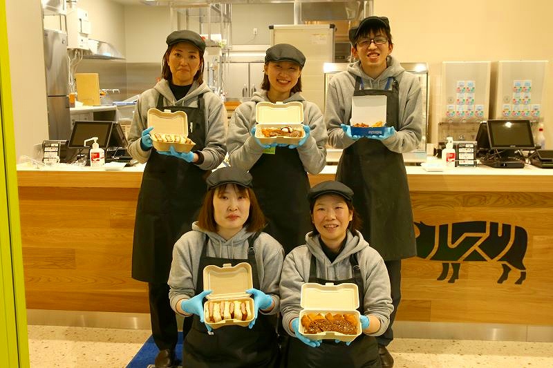 笑顔で商品を手にPRする「ルスツ羊蹄ぶた」のスタッフ