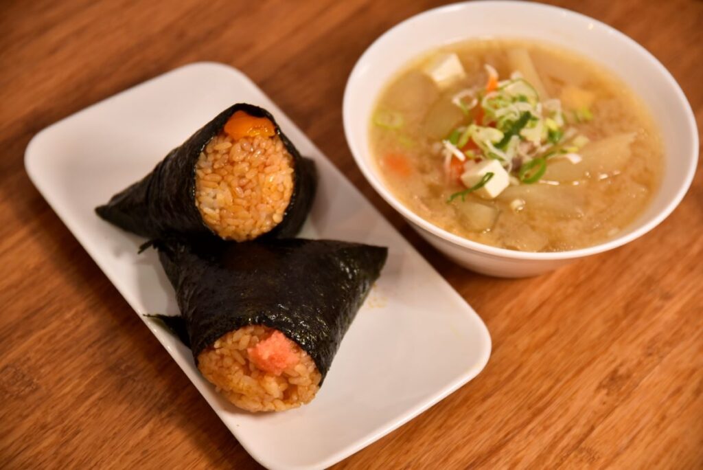 「名代にぎりめし」の「たらこバター 醤油にぎり」（手前）と「卵黄の味噌漬け」（奥）、右は「とん汁」