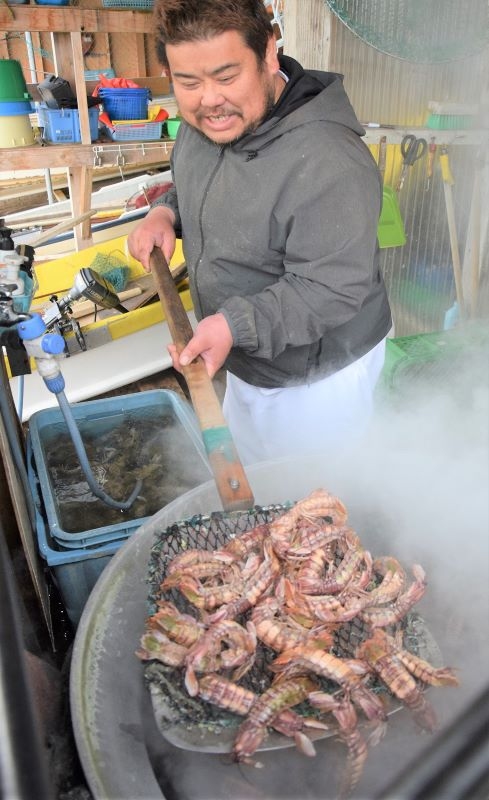 ゆであがったシャコを網ですくう成田学さん