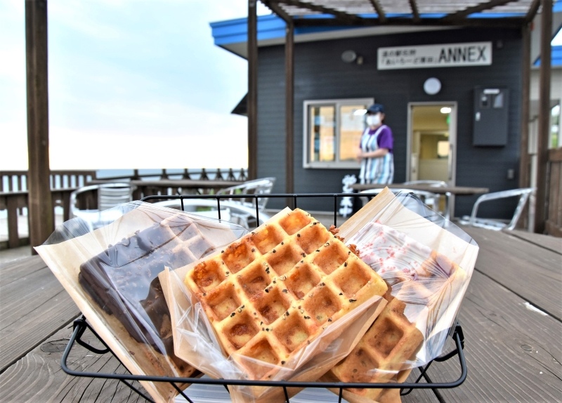 「厚田サンセットテラス&BBQガーデン」の生おからワッフル。奥が店舗で、テラス席から日本海が一望できる