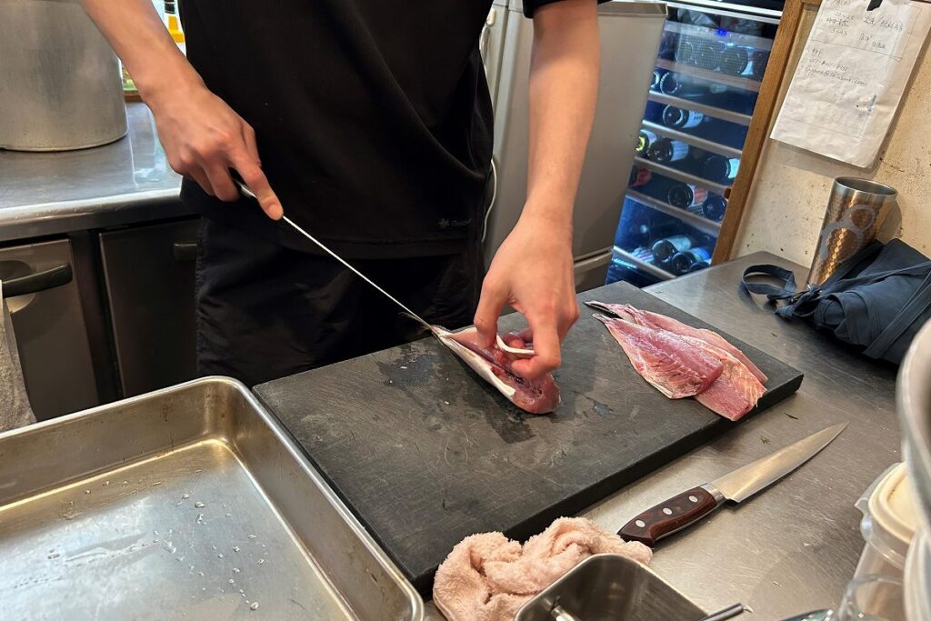 「ステム」の厨房でさばかれるアジ