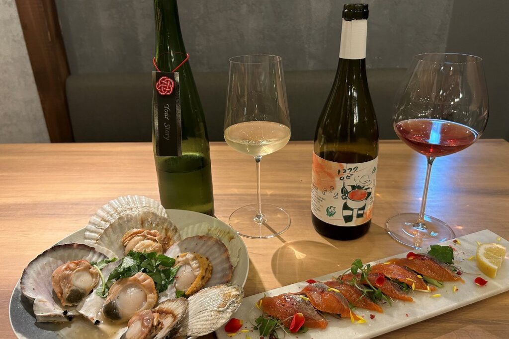 「うぉんたな」のホタテの白ワインガーリックバター蒸し(左)とサクラマスのカルパッチョ