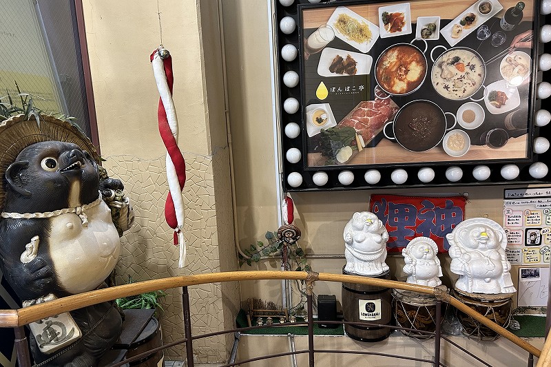 リニューアル前のシンボルだった大きなタヌキと白く塗り替えたタヌキが飾られている店内