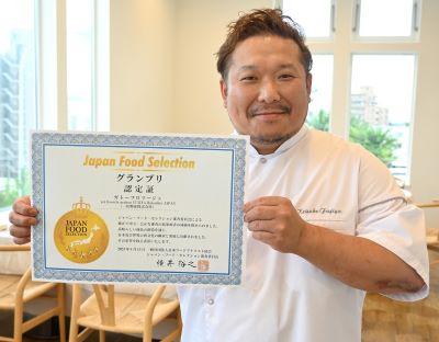 グランプリの賞状を手に、笑顔を見せる統括シェフの藤谷圭介さん