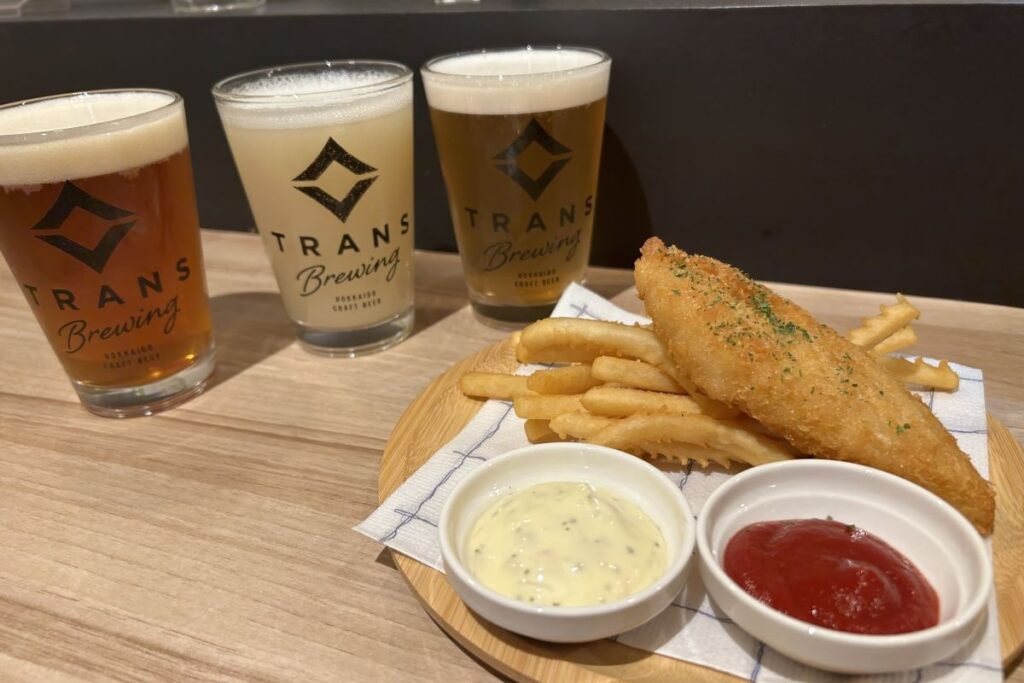 ３杯のビールグラスとフードの「ミニフィッシュ＆チップス」
