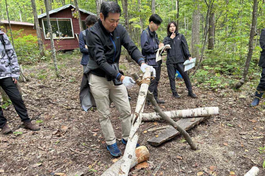 丸太を「V」字型に麻縄で縛る参加者