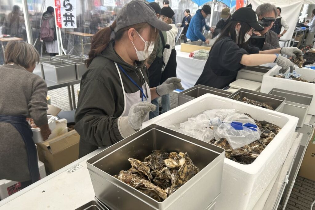 缶にカキを詰めていくスタッフ