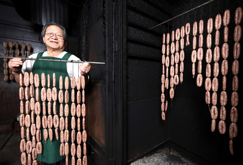 ナラの木を燃やし、豚肉をじっくりとじか火で薫煙する浦上孝さん