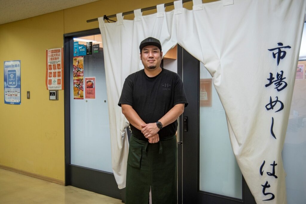 お店の前に立つ店長の福永敦史さん