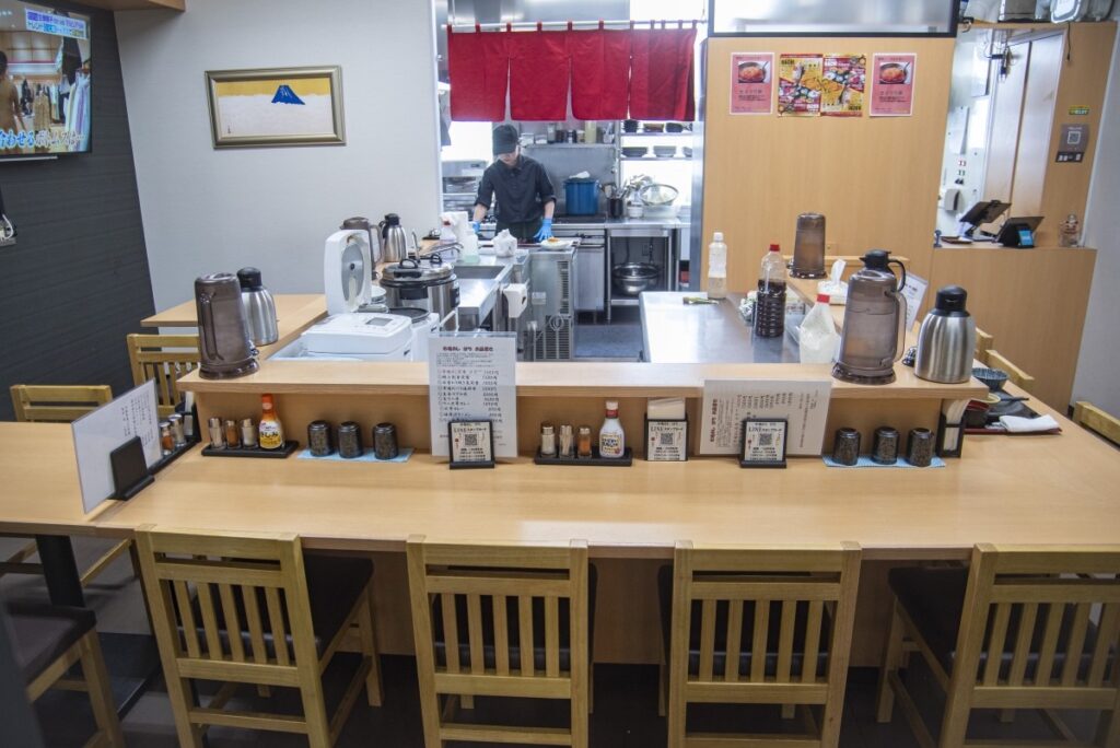 カウンター席とテーブル席がコの字になった清潔感あふれる店内