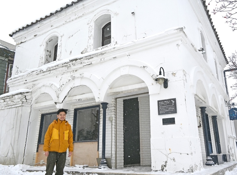 ３連アーチなど建築当時の趣を生かした「ポートサイドインハコダテ」の外観と運営法人取締役の園部優樹さん