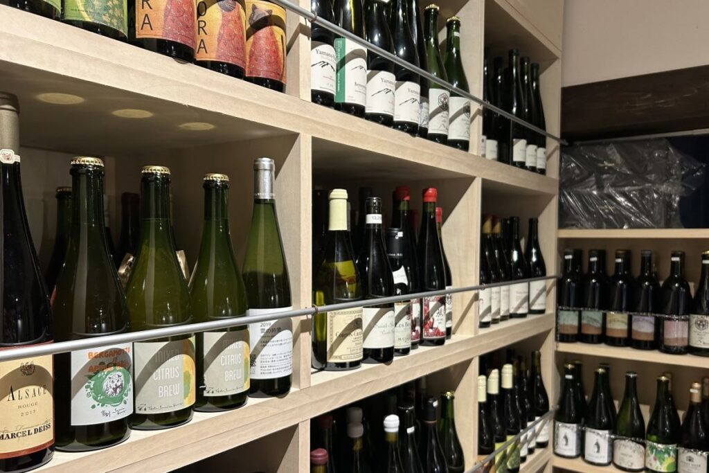 マガッツィーノ店内の棚に並ぶ当別セブンズ・ブルワリーのビール（手前）。上段や右側に並ぶワインと見まごいそう