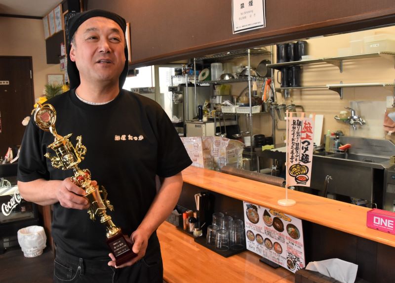 従業員から贈られた10周年トロフィーを手にする増井さん