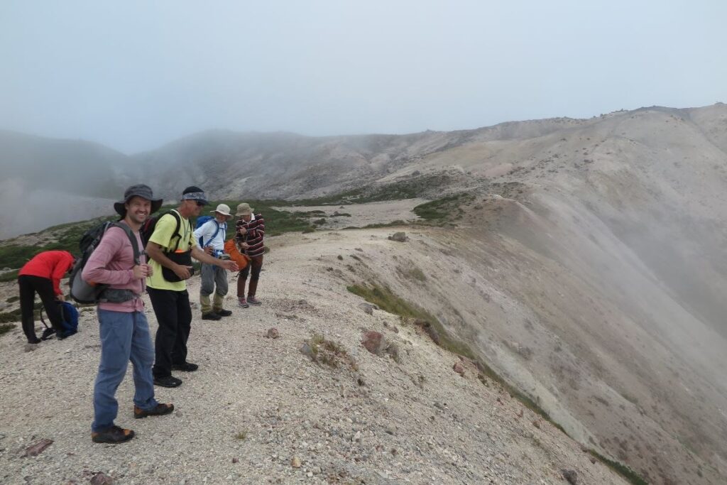 活火山イワオヌプリの火口を眺める参加者