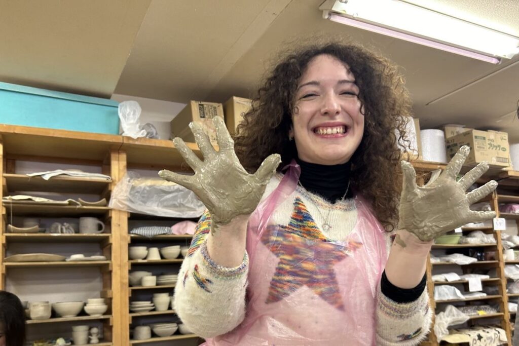 粘土で手を汚しながらも、楽しそうな参加者の女性