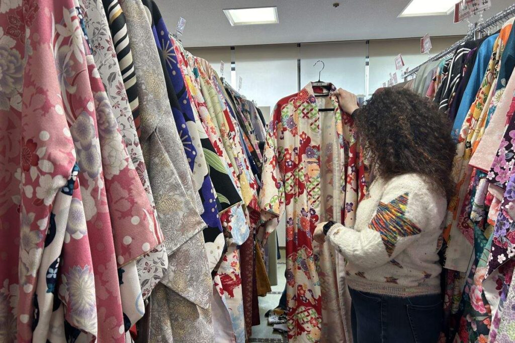 ずらりと掛けられた着物の中から自分好みのものを楽しそうに選ぶ参加者