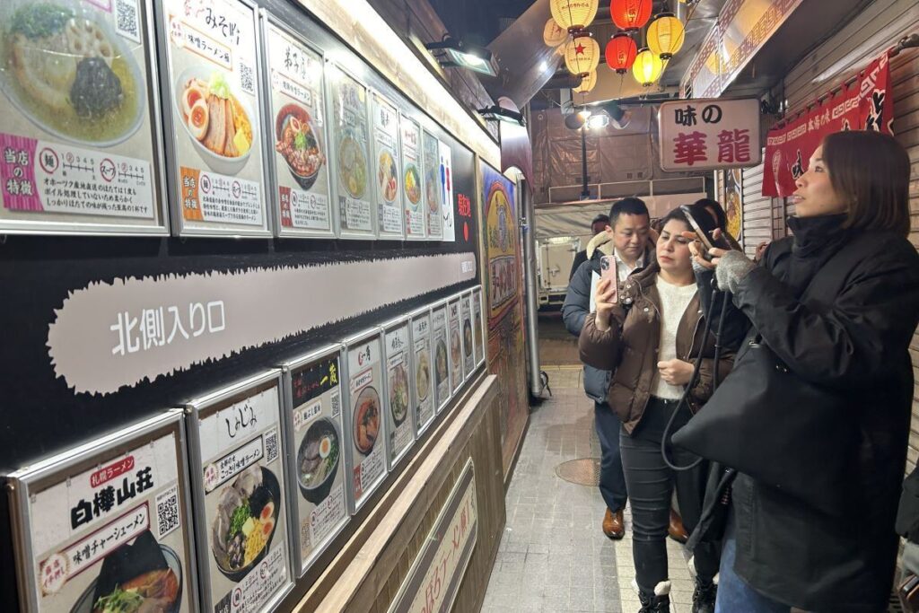 元祖さっぽろラーメン横丁の各店のメニューに見入る参加者