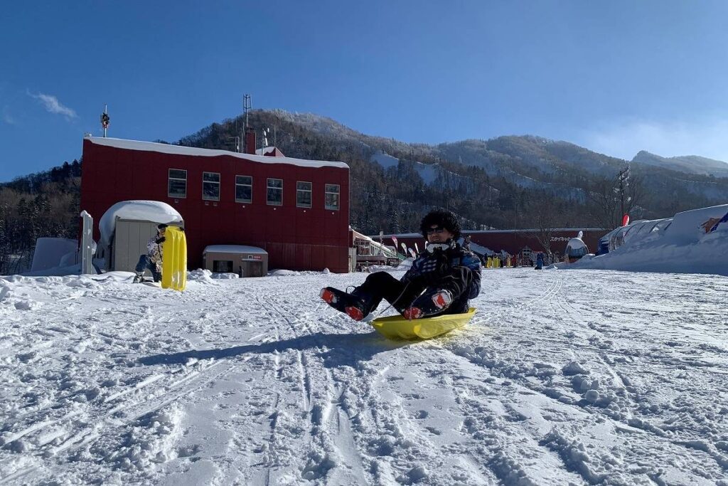 雪を楽しもうと、まずはそり滑りに挑戦する参加者