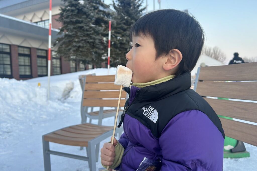 こげ目が付いてとろりとしたマシュマロをぱくっと食べる子ども
